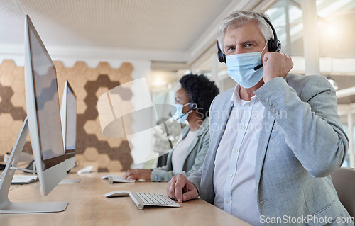 Image of Covid, portrait and man in a call center for service, online help and advice on a computer. Talking, telemarketing and mature customer support employee wearing a face mask while consulting on a pc