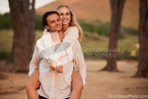 Image of Love, piggy back and couple in forest, quality time and celebrate anniversary, relationship and happiness. Romance, happy man carry woman and smile outdoor, calm and loving with joy, bonding or break