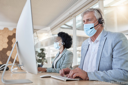 Image of Covid, help desk employees with mask at computer and mature man and black woman in call center. Office compliance, consulting team online in coworking space and medical advisory agency with diversity