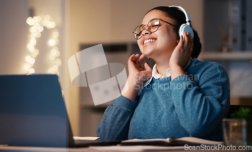 Image of Music headphones, student and woman in home at night streaming radio or podcast after elearning. Freelancer, remote worker or happy business female listening or enjoying audio, song or album in house