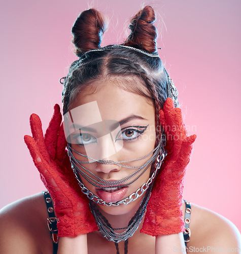 Image of Chains, fashion and face of goth woman with unique style isolated against a studio pink background. Portrait, accessories and edgy female model metal jewelry on her head and cool makeup