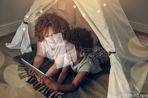 Image of Black family, tablet and mother with kid in tent at night watching movie, video and having fun in home. Technology, bokeh and smile of happy African mom bonding with boy child while streaming film