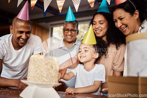 Image of Birthday, black family and a girl cutting cake in the home during a party or celebration together. Kids, event or love with parents, grandparents and a daughter bonding or celebrating in a house