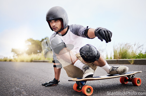 Image of Skateboard slide, action and man in road for sports competition, training and balance in city. Skating, skateboarding hobby and male skater in gear riding for speed, adventure and race adrenaline