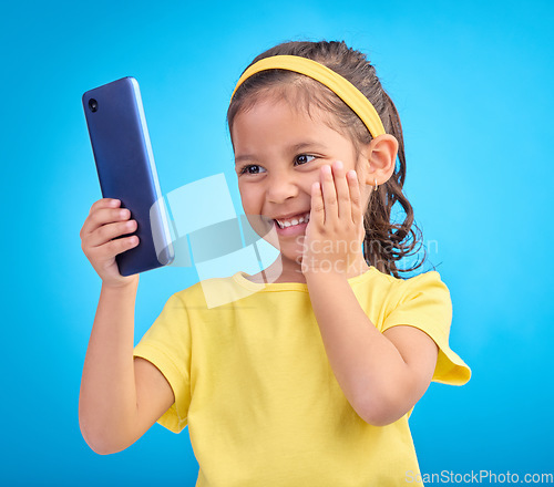 Image of Wow, excited and girl with smartphone, social media and cheerful kid against a blue studio background. Latino female, happy young person and cellphone with connection, happiness and watching video