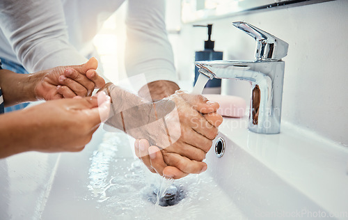 Image of Cleaning hands, family and washing in sink in bathroom for health, hygiene and wellness. Water splash, children and father with kid to wash with soap for disinfection, sanitize or skincare in house.