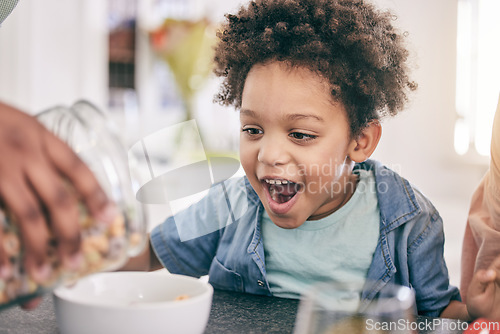 Image of Excited, happy and child ready for breakfast cereal in the morning feeling hungry for cornflakes in a home or house. Kid, food and young boy in the kitchen smile due to meal sitting at table