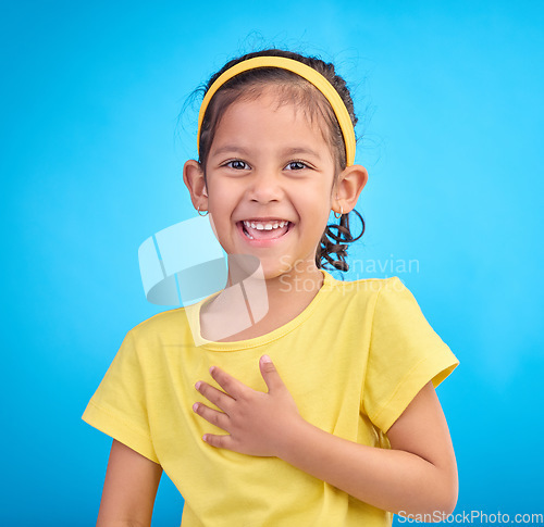 Image of Child laugh, happy portrait and smile of a little girl in a studio with blue background feeling cute. Happiness, adorable and face of a confident, playful and fun kid laughing about a funny joke