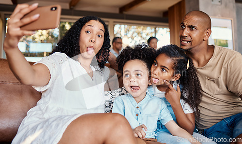 Image of Family, funny face and selfie with tongue out in home, having fun and bonding together. Interracial, comic photography and father, mother and girls taking pictures for social media and happy memory.