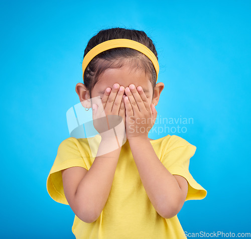 Image of Cover eyes, hands on face and child on blue background for shy, mistake expression and sad in studio. Emotion reaction, childhood and young girl isolated for hide and seek, surprise and blind emoji