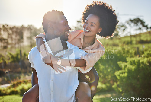 Image of Black couple, piggy back or bonding in park, nature garden or sustainability environment in fun activity game or love. Smile, happy man or afro woman in carry support, trust or freedom playful date