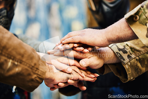 Image of Motivation, paintball team or hands in huddle on a mission, friends or soldier training on war battlefield. Goal, collaboration or army people with support in partnership or military group solidarity