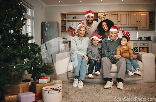 Image of Christmas, big family and portrait smile in living room on sofa in home, bonding and care. Xmas, interracial and happy grandmother, grandfather and parents with kids or children enjoying holiday.