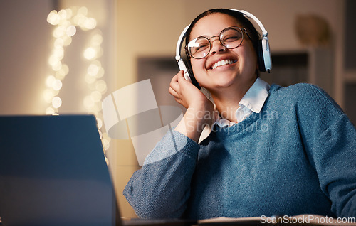 Image of Student, music headphones and woman in home at night streaming radio or podcast after elearning. Freelancer, remote worker or happy business female listening or enjoying audio, song or album in house