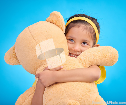 Image of Mockup, portrait and girl with teddy bear, hug and happiness against a blue studio background. Face, female kid and young person embrace fluffy toy, cheerful and child development with fun and joy