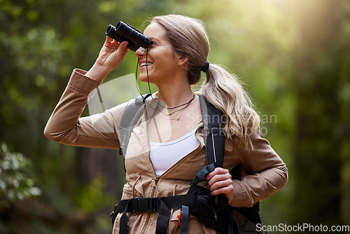 Image of Binoculars, forest and hiking woman for travel journey, jungle adventure and nature explore with backpack and gear. Happy hiker or camper person trekking in woods and search or birdwatching outdoor