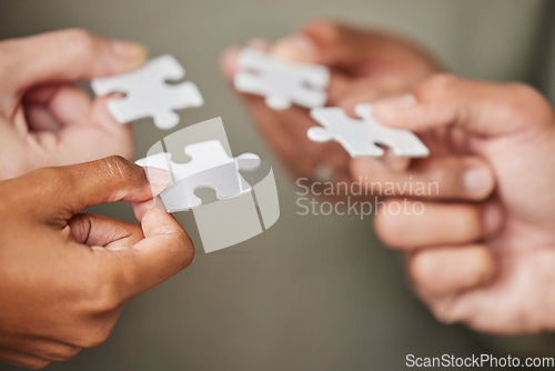 Image of Business people, hands and puzzle piece for collaboration, planning or team building strategy at office. Hand of group in teamwork for goal, support or motivation in cooperation for problem solving