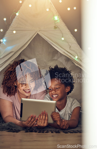 Image of Tablet, black family and mother with kid in tent at night watching movie, video and having fun in home. Technology, love and smile of happy mixed race mom bonding with boy child while streaming film.
