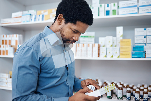 Image of Pharmacy, shopping and man reading medicine box, customer supplements product or drugs store pharmaceutical. Retail hospital shop, clinic pills shelf and African client for medical healthcare choice