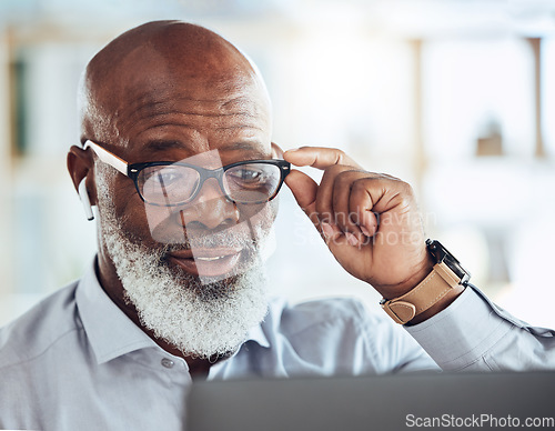 Image of Black man, business glasses and reading laptop in corporate office, online news article and website. Mature manager, computer technology and earphones for video call, virtual working and management