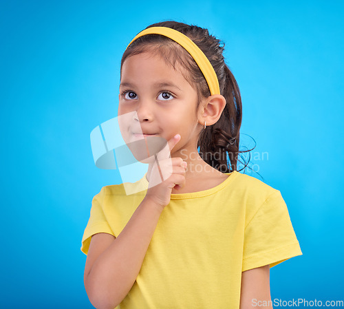 Image of Thinking, idea and face of child in studio with contemplation, thoughtful and planning expression. Ideas mockup, innovation and young girl on blue background for brainstorming, question and curious