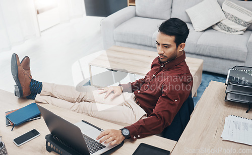 Image of Work from home man with feet up on desk working on laptop for job confidence, productivity and online career. Asian remote worker, entrepreneur or professional person relaxing and typing on computer