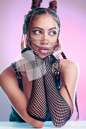 Image of Metal, rock and beauty of a woman with makeup, bondage and bdsm style in a studio. Isolated, pink background and punk aesthetic of a gen z person and hispanic model with leather rocker clothing