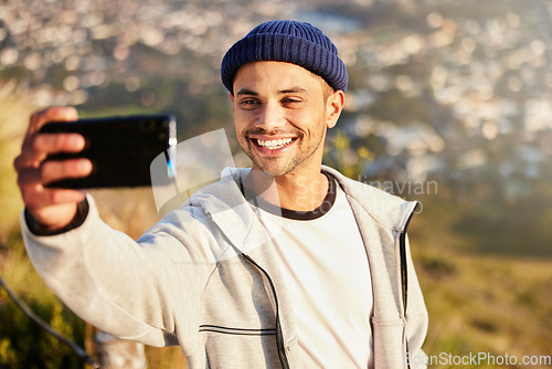 Image of Fitness, selfie and male hiking on the mountain after walking for a wellness exercise in nature. Sports, health and young man hiker taking a picture while trekking outdoor for a cardio workout.