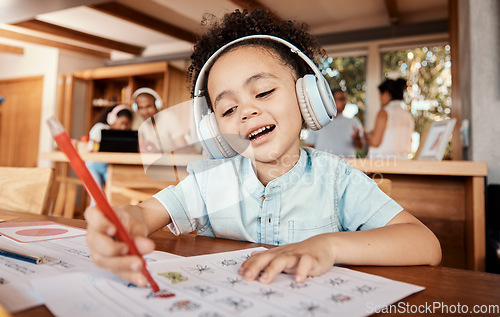 Image of Distance learning, headphones and student doing homework while listening to music, audio book or radio. Home school, education of young kid or boy child writing on paper for academic or project