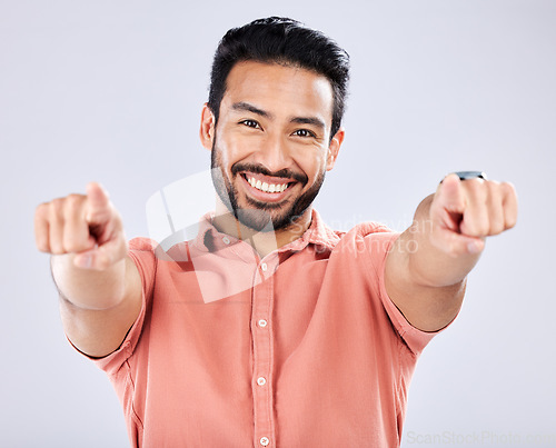 Image of Portrait, pointing and motivation with a man in studio on a gray background choosing an option or selection. Happy, smile and hey you with a handsome young male making a choice or decision