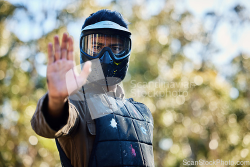 Image of Man, paintball and hands in stop signal for team communication or strategy on the battlefield in nature. Male paintballer or soldier showing hand sign halt or wait in adrenaline sport outdoors