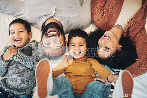 Image of Happy, above and portrait of a family on a bed for relaxation, bonding and quality time. Laughing, smile and carefree parents with children in the bedroom to relax and play in the morning together