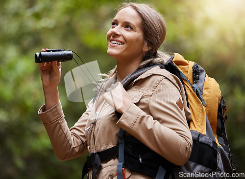 Image of Nature, hiking and woman with binoculars, adventure trail on holiday in African game reserve. Trekking, trees and forest hike, sightseeing and person with smile on happy mountain walk in South Africa