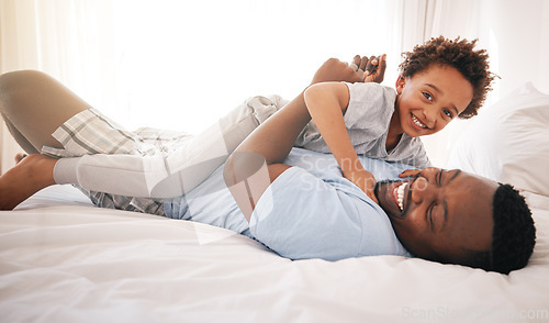 Image of Children, love and bedroom with a playful black family having fun in the morning together after waking up. Kids, smile or laughing with a father and happy son playing or joking on a bed in their home