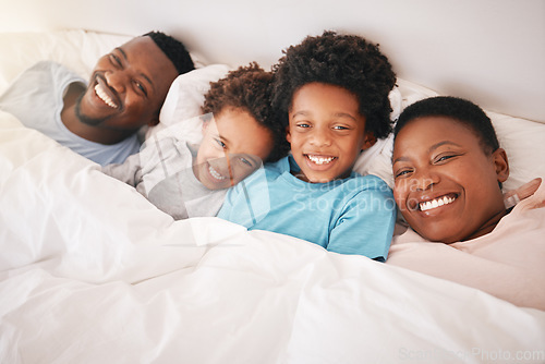 Image of Smile, happy and relax with black family in bedroom for bonding, wake up and morning routine from top view. Care, funny and cute with parents and children at home for calm, weekend and quality time
