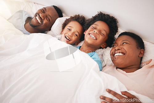 Image of Funny, happy and relax with black family in bedroom for bonding, wake up and morning routine from top view. Smile, laugh and cute with parents and children at home for calm, weekend and quality time