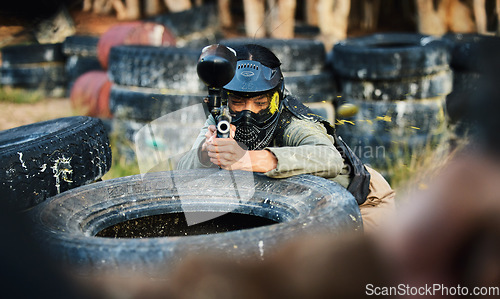 Image of Paintball, person aim gun at target and military tactics, shooting range and war game for sports outdoor. Soldier with weapon on battlefield, action and camouflage, helmet for safety and adventure