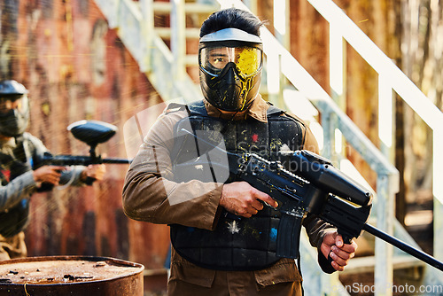 Image of Portrait, paintball or man with gun in a game or competition for fitness, exercise or cardio workout. Focus, challenge or serious male athlete carrying an army weapon or marker for military training