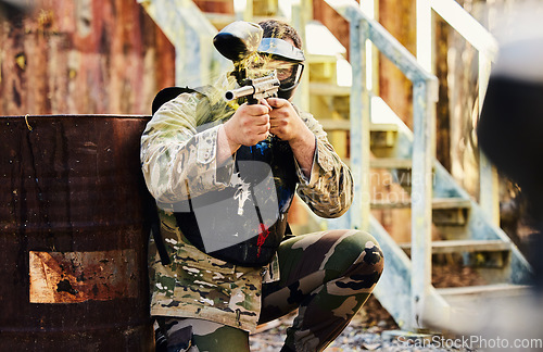 Image of Paintball, military or man with gun in shooting game playing with on fun battlefield mission. Target, warrior or focused soldier with army weapons gear for survival in outdoor challenge competition