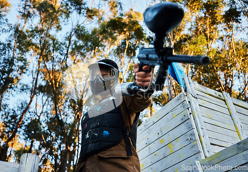 Image of Paintball, gun and violence with a sports man on a battlefield for military or war training for the army. Fitness, team building and safety with a male athlete or soldier playing a game outdoor