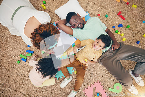 Image of Top view, family and parents with children on floor with toys, number puzzle and bonding at home. Happy, educational games and mom, dad and kids smile for fun activity, creative learning and relax