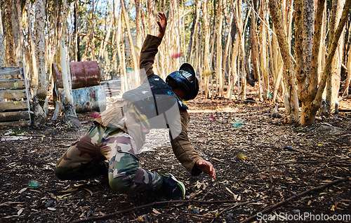 Image of Man, paintball and dodging shots in the matrix for intense battle or war in the forest on knees. Male paintballer or soldier ducking to dodge paint balls in extreme adrenaline sports outdoors