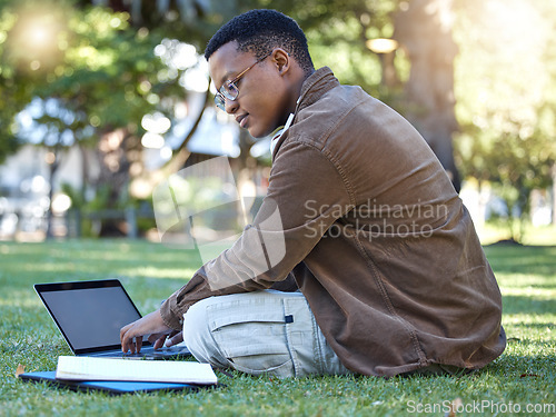 Image of Black man reading, park and student laptop work in a garden with a education book and lens flare, Outdoor, happiness and elearning with a textbook of a person busy with exam study on university grass