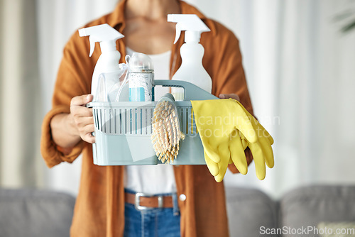 Image of Hands, housekeeper and woman maid cleaning home with equipment, housework and person for hygiene clean house. Maintenance, service and basket of disinfectant product by worker in living room