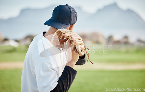 Image of Pitcher, back view or baseball player training for a sports game on outdoor field stadium. Fitness, young softball athlete or focused man pitching or throwing a ball with glove in workout or exercise