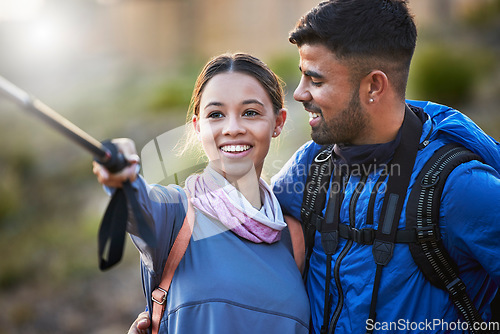 Image of Couple, hiking selfie and backpack together for smile, happiness and adventure for fitness on mountain. Gen z man, woman and outdoor with stick for social media, profile picture or training with love