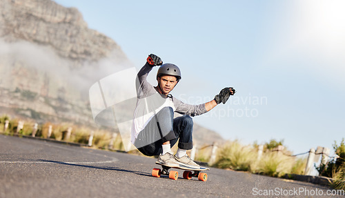 Image of Skateboard, action and man slide in road for sports competition, training and exercise on mountain. Skating, skateboarding and male skater riding for speed, adventure and freedom for extreme sport