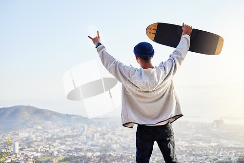 Image of Skateboard, winner and mountains with man cheering for fitness, sports and adventure. Happiness, success and training with gen z guy and hands up in outdoors for skating, wellness and summer break