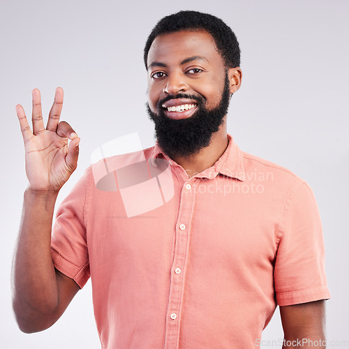 Image of Portrait, perfect and hand gesture with a black man in studio on a gray background to say magnifique. Emoji, communication and okay with a happy or handsome young male speaking in sign language