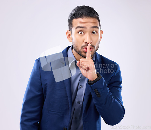 Image of Portrait, business man and finger on lips in studio, background and privacy secret. Male employee, silence hands and quiet mouth for shush sign, gossip or whisper in silent emoji of corporate mystery